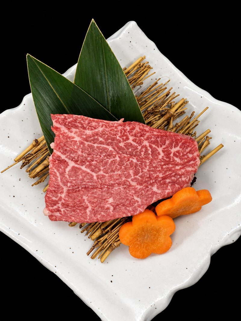白い角皿に載せた、細かな霜降りの入った塊の肉
