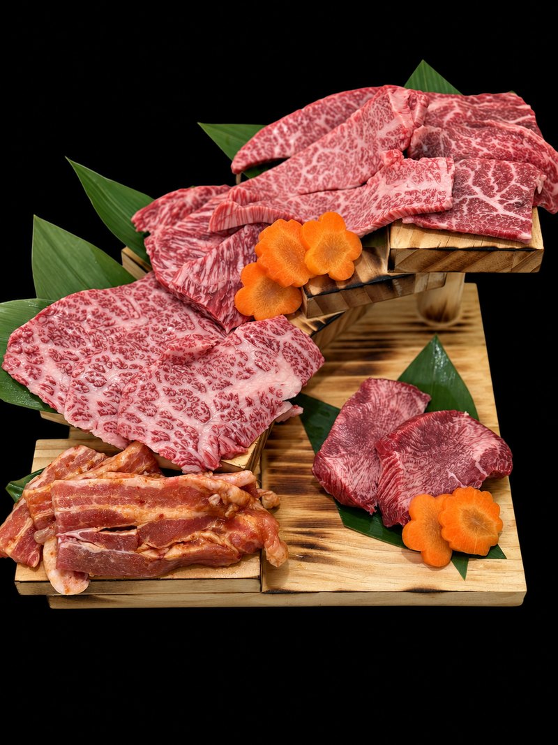 木の盛り台に、霜降りの焼肉や薄切りの肉を笹の葉とともに盛り合わせた一皿